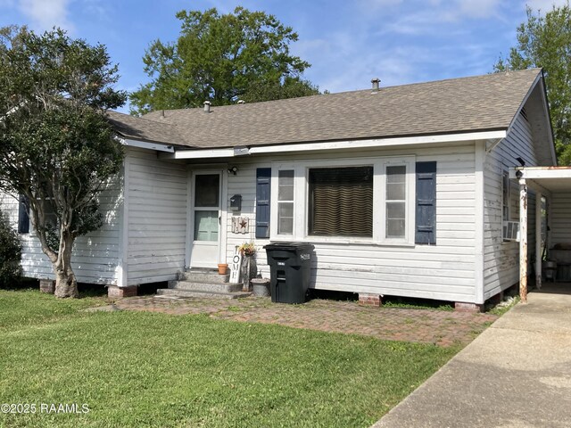 view of front of house featuring a front yard, a shingled roof, and entry steps