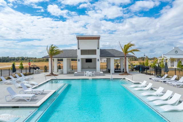 community pool featuring an outbuilding, an exterior structure, fence, and a patio