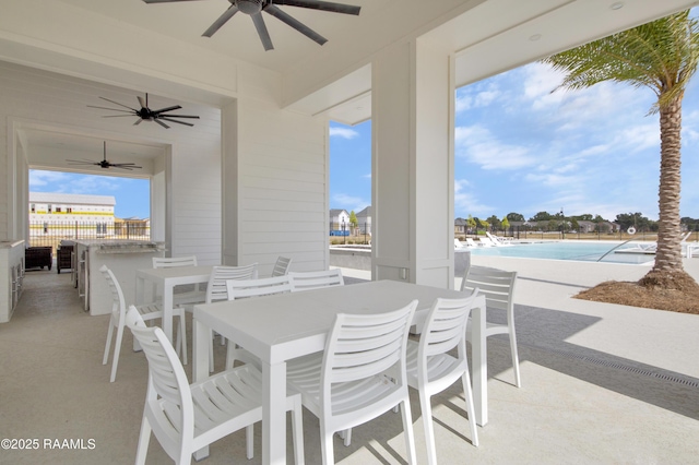 view of patio / terrace featuring outdoor dining area, ceiling fan, and a community pool