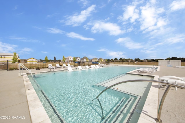 community pool with fence and a patio