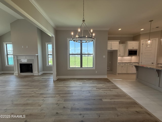 205 Keystone Dr, Scott, LA 70583 - kitchen with stainless steel microwave, a chandelier, white cabinetry, a kitchen bar, and recessed lighting
