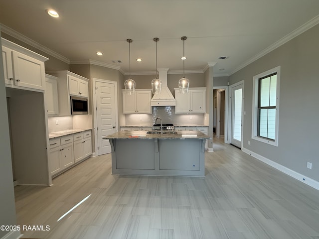 205 Keystone Dr, Scott, LA 70583 - kitchen with stainless steel microwave, custom range hood, backsplash, white cabinets, and recessed lighting