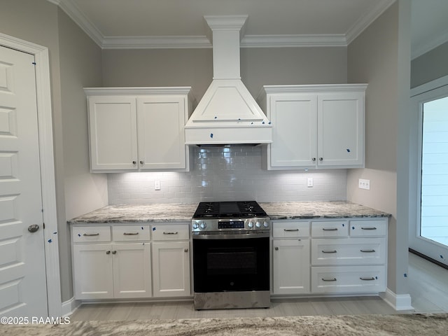 205 Keystone Dr, Scott, LA 70583 - kitchen with gas stove, custom range hood, ornamental molding, white cabinets, and backsplash