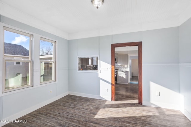 empty room featuring baseboards and wood finished floors