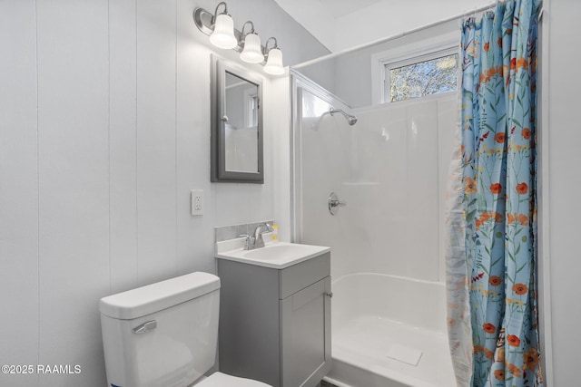 bathroom with toilet, vanity, and a stall shower