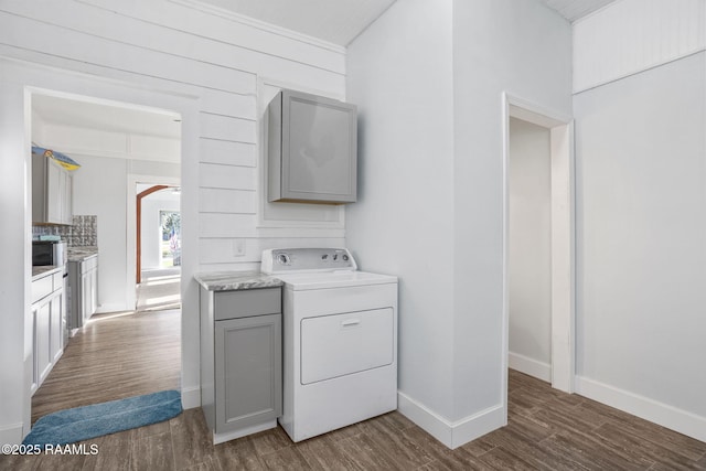 laundry room with dark wood-type flooring, arched walkways, baseboards, and washer / dryer