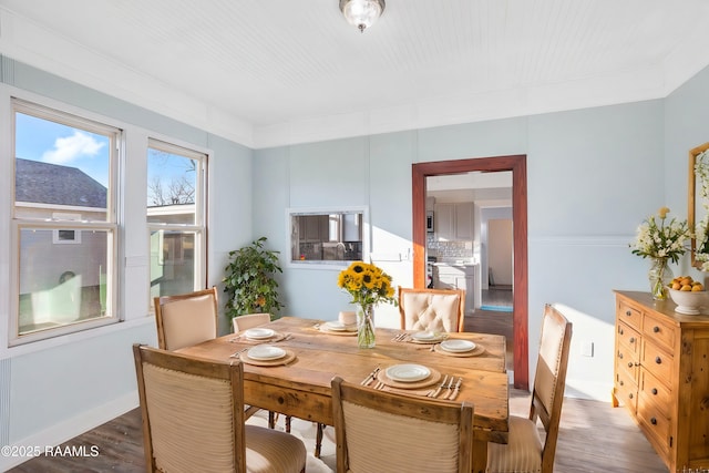 dining area with baseboards and wood finished floors