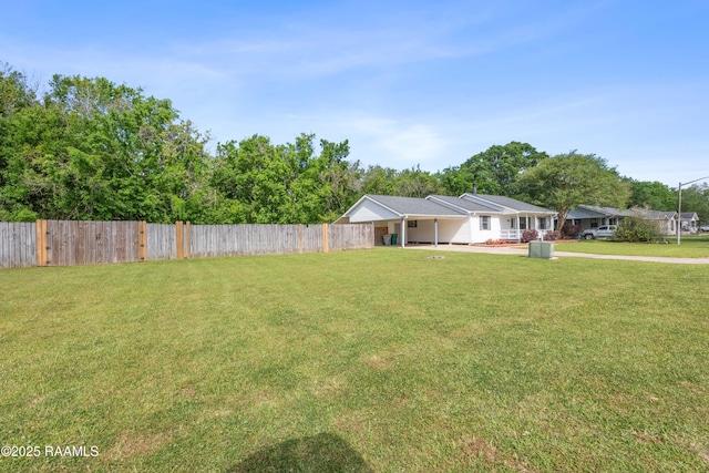 view of yard with a carport and fence