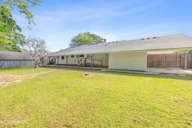 rear view of house with a patio, a yard, and a fenced backyard