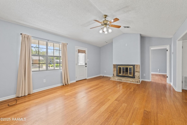 unfurnished living room featuring visible vents, ceiling fan, vaulted ceiling, and a textured ceiling