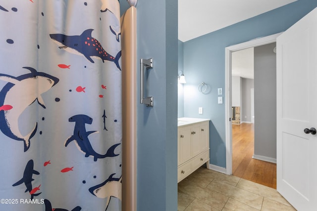 bathroom with tile patterned floors, vanity, and baseboards