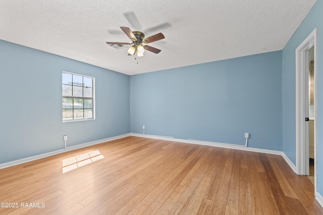 unfurnished room with baseboards, a ceiling fan, wood finished floors, and a textured ceiling
