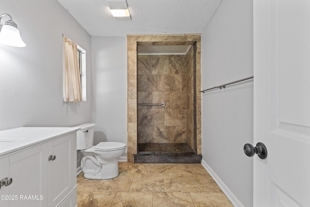 bathroom with tiled shower, vanity, baseboards, and toilet