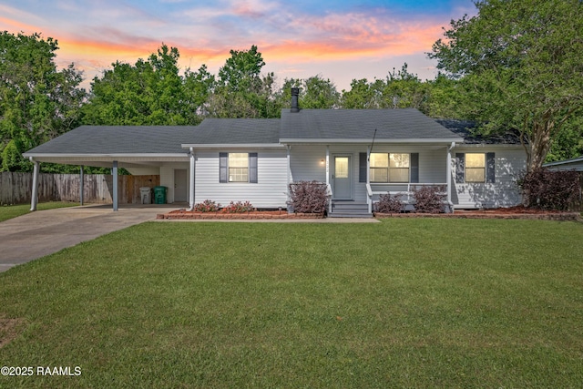 ranch-style house with a lawn, driveway, an attached carport, fence, and a shingled roof