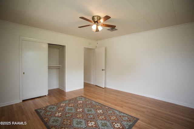 4189 Poydras Hwy, Breaux Bridge, LA 70517 - unfurnished bedroom featuring a closet, crown molding, wood finished floors, baseboards, and visible vents