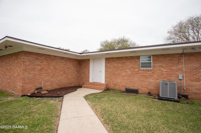 4189 Poydras Hwy, Breaux Bridge, LA 70517 - view of exterior entry featuring central AC unit, a lawn, and brick siding