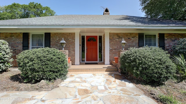 1217 Wellington Ave, Opelousas, LA 70570 - view of front of property featuring a shingled roof, brick siding, and a porch