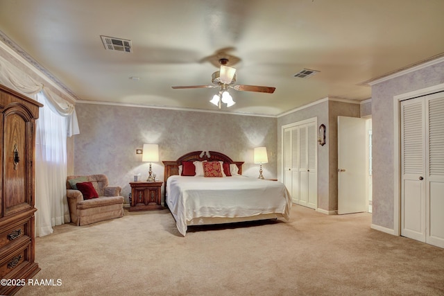 1217 Wellington Ave, Opelousas, LA 70570 - carpeted bedroom featuring multiple closets, visible vents, a ceiling fan, and ornamental molding