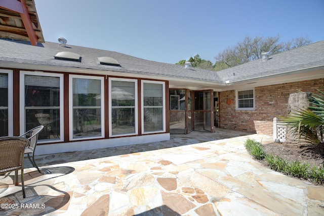 1217 Wellington Ave, Opelousas, LA 70570 - rear view of house featuring roof with shingles, a patio area, and brick siding