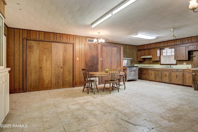 1217 Wellington Ave, Opelousas, LA 70570 - dining space featuring light floors, a chandelier, visible vents, and wooden walls