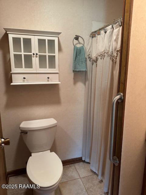 1217 Wellington Ave, Opelousas, LA 70570 - full bath with tile patterned flooring, toilet, a shower with curtain, and baseboards