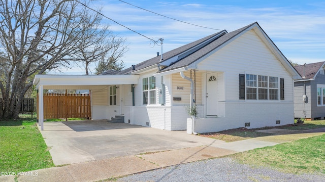 bungalow featuring fence, crawl space, an attached carport, brick siding, and driveway