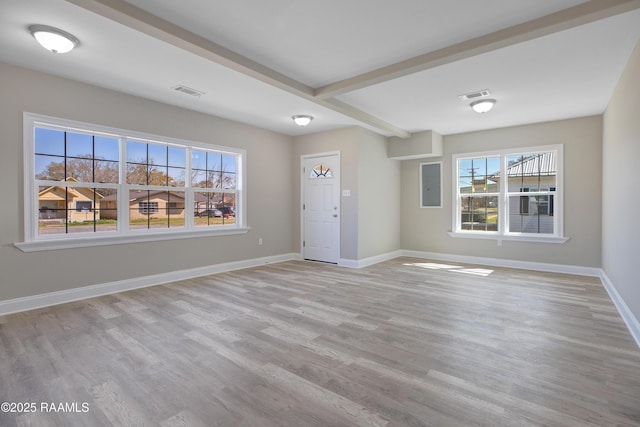 unfurnished living room with baseboards, visible vents, light wood-style flooring, and beam ceiling