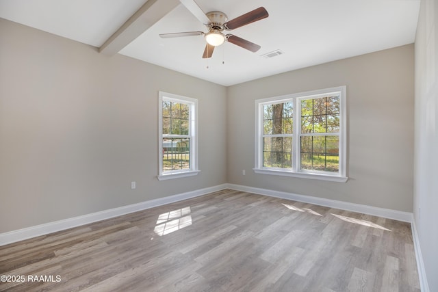 empty room with wood finished floors, beamed ceiling, baseboards, visible vents, and ceiling fan