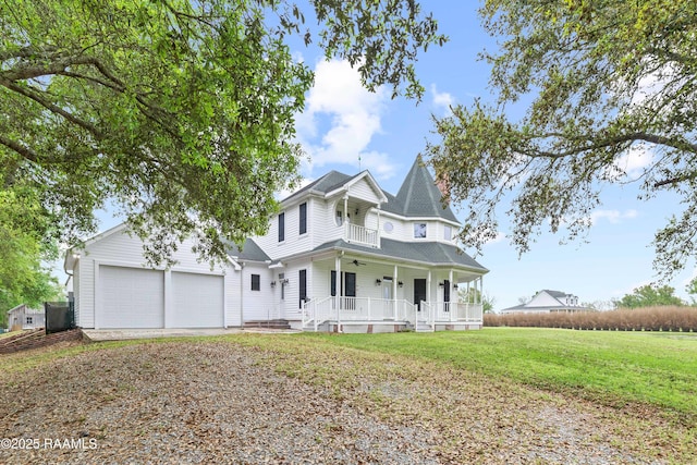 victorian house with ceiling fan, a porch, roof with shingles, a front lawn, and a garage