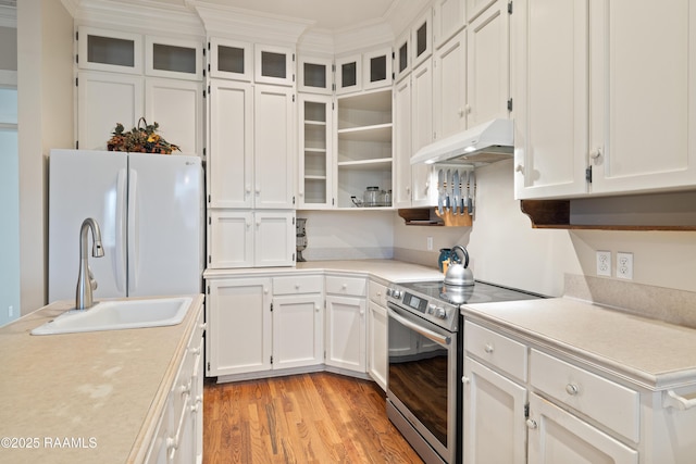 kitchen with freestanding refrigerator, white cabinetry, under cabinet range hood, light countertops, and electric stove