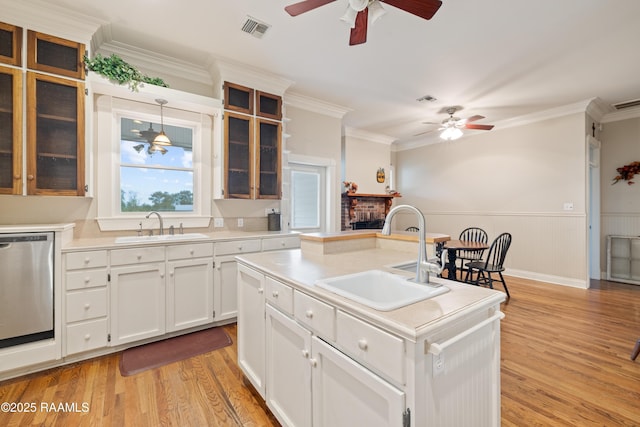 kitchen with stainless steel dishwasher, a sink, a ceiling fan, and visible vents