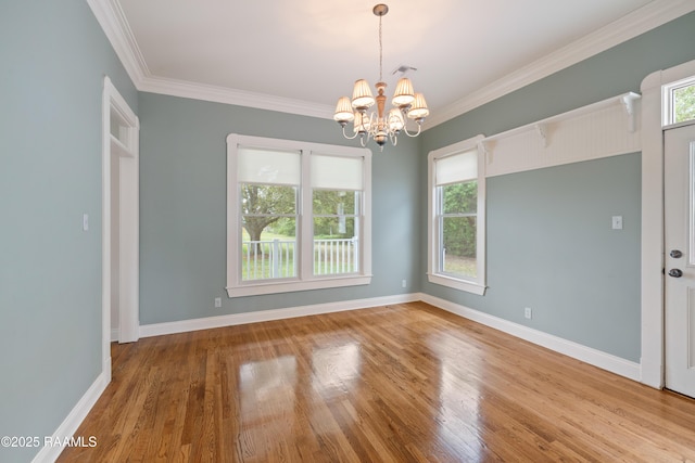 unfurnished room with crown molding, a chandelier, and wood finished floors