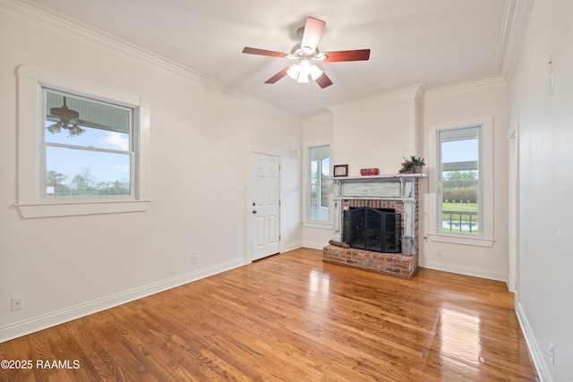 unfurnished living room with baseboards, a brick fireplace, ceiling fan, crown molding, and light wood finished floors