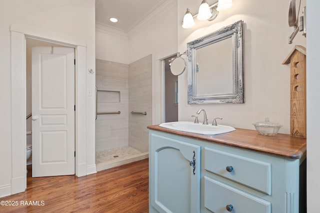 bathroom with vanity, ornamental molding, toilet, a walk in shower, and wood finished floors