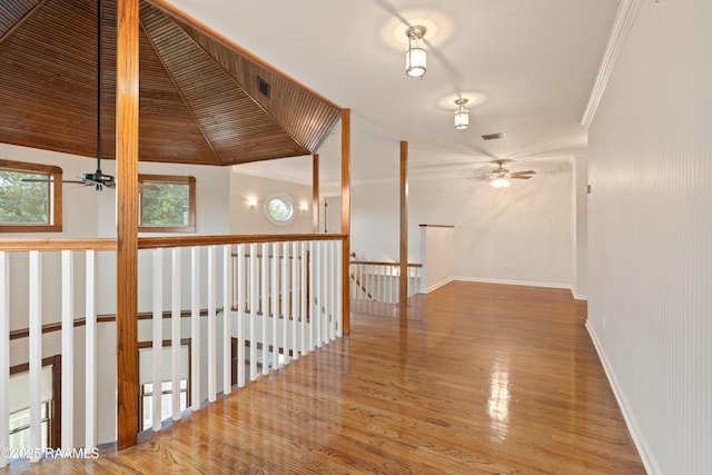 corridor with visible vents, ornamental molding, an upstairs landing, and wood finished floors