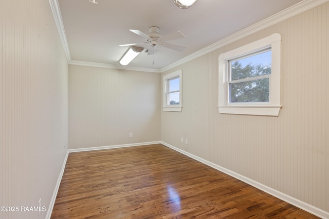 unfurnished room with crown molding, wood finished floors, baseboards, and a ceiling fan