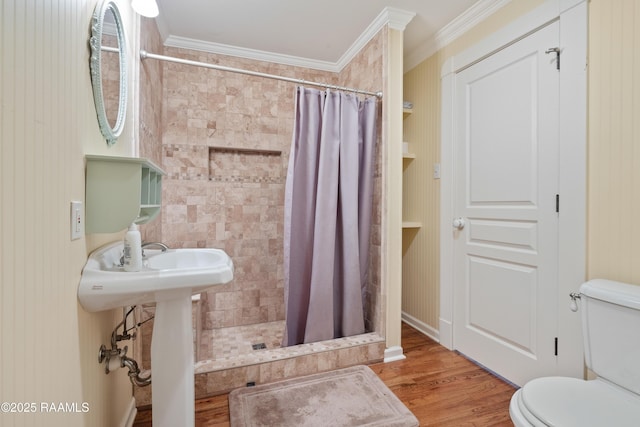 full bathroom with a shower stall, crown molding, toilet, and wood finished floors