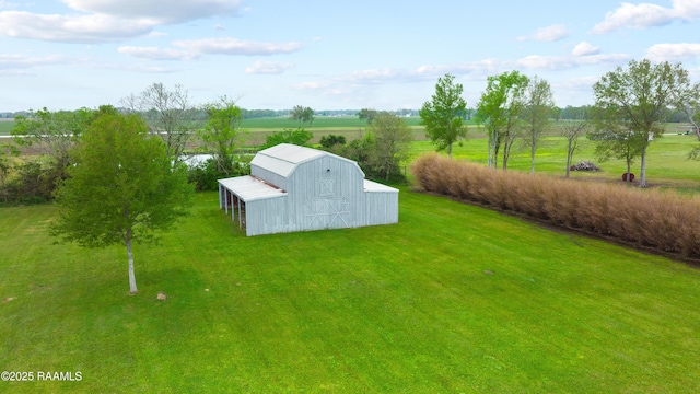 view of yard featuring an outdoor structure, a barn, and a rural view