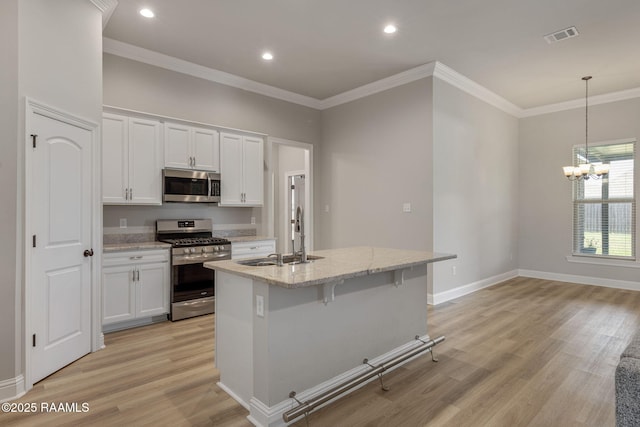 kitchen with visible vents, appliances with stainless steel finishes, white cabinetry, a sink, and light wood-style flooring