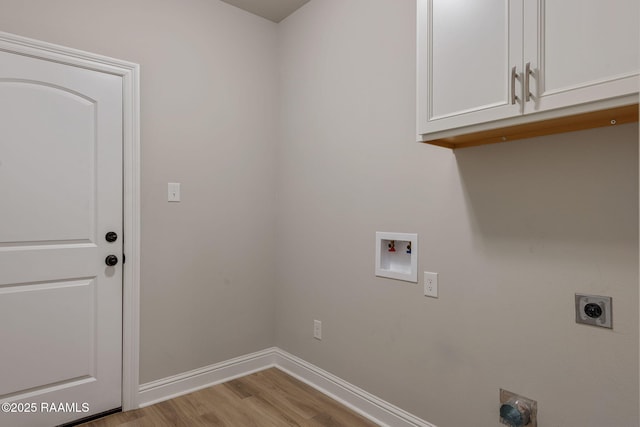 clothes washing area featuring baseboards, light wood-type flooring, hookup for an electric dryer, cabinet space, and washer hookup