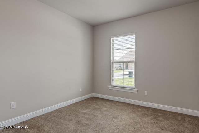 carpeted spare room featuring baseboards