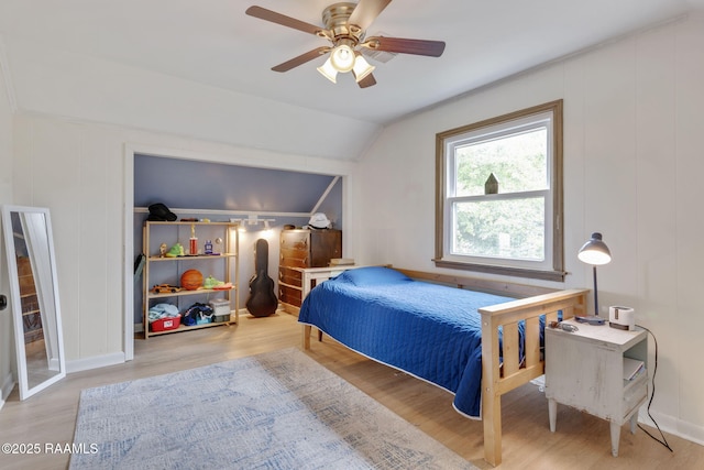bedroom with vaulted ceiling, wood finished floors, and ceiling fan