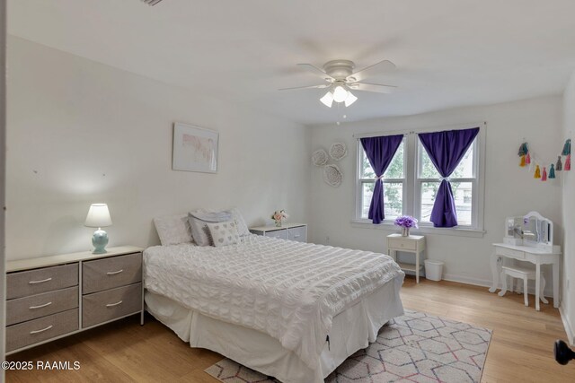 bedroom with wood finished floors, a ceiling fan, and baseboards