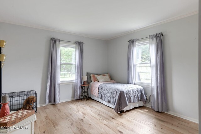 bedroom with baseboards, ornamental molding, and light wood-style flooring