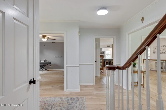 entryway with a ceiling fan, baseboards, ornamental molding, and light wood-type flooring