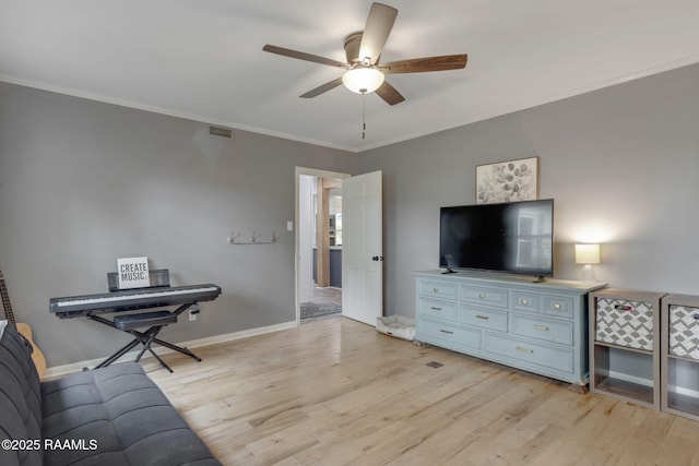 living area with light wood-type flooring, baseboards, visible vents, a ceiling fan, and ornamental molding