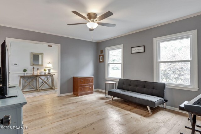 living area with light wood-type flooring, a ceiling fan, and ornamental molding