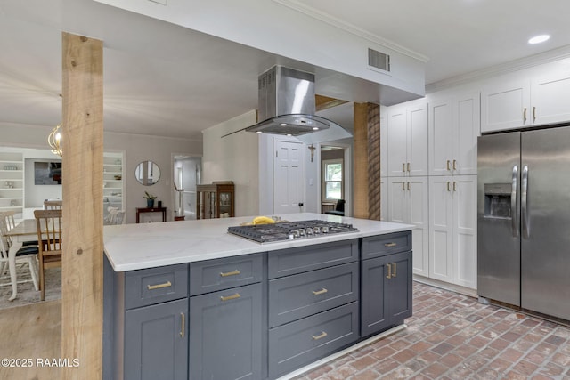 kitchen featuring appliances with stainless steel finishes, white cabinets, ornamental molding, visible vents, and ventilation hood