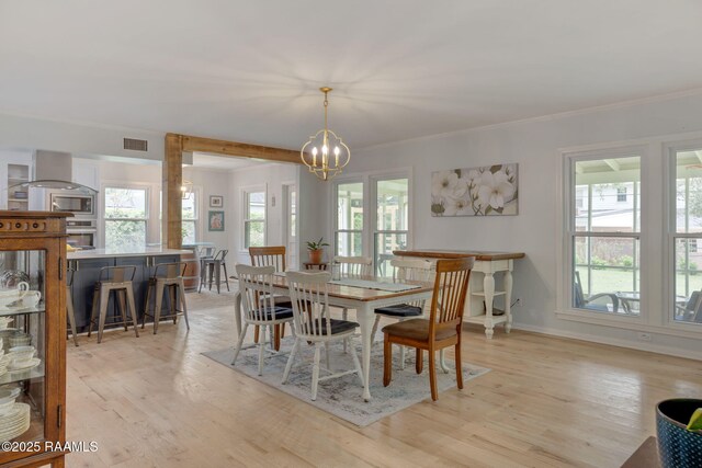 dining space with baseboards, an inviting chandelier, visible vents, and light wood-style flooring