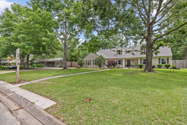 ranch-style house featuring fence and a front yard
